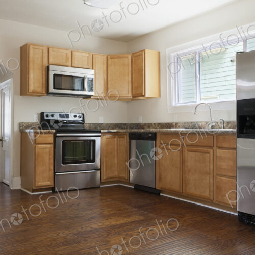 A contemporary kitchen with hardwood floors and stainless steel appliances.