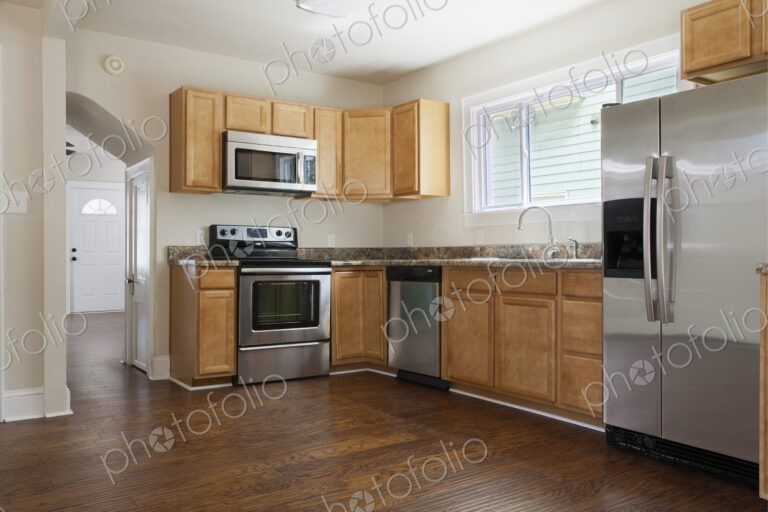 A contemporary kitchen with hardwood floors and stainless steel appliances.
