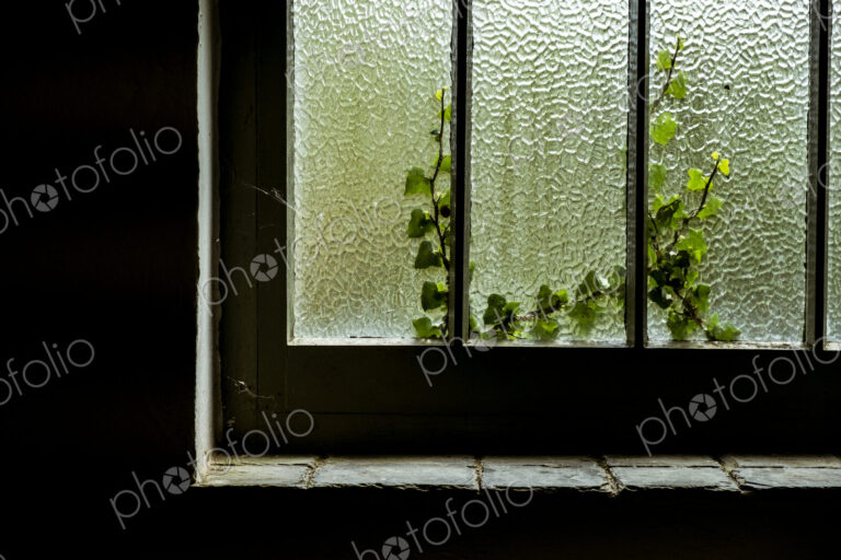 A cottage window with a crackle glaze opague effect, woodwork with paint, and a stone…