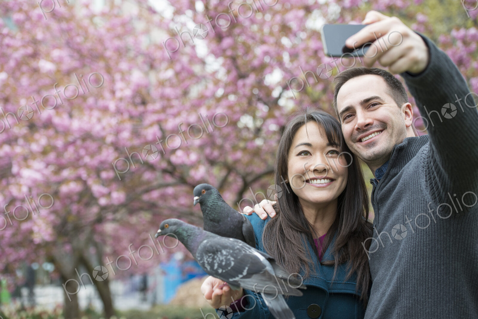 A couple, a man and woman, in the park, taking a selfy, self portrait with a mobile…
