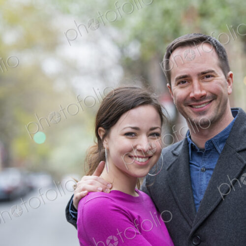 A couple, a man and woman side by side on a city street.