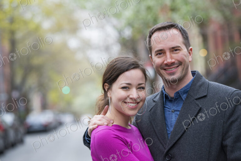 A couple, a man and woman side by side on a city street.
