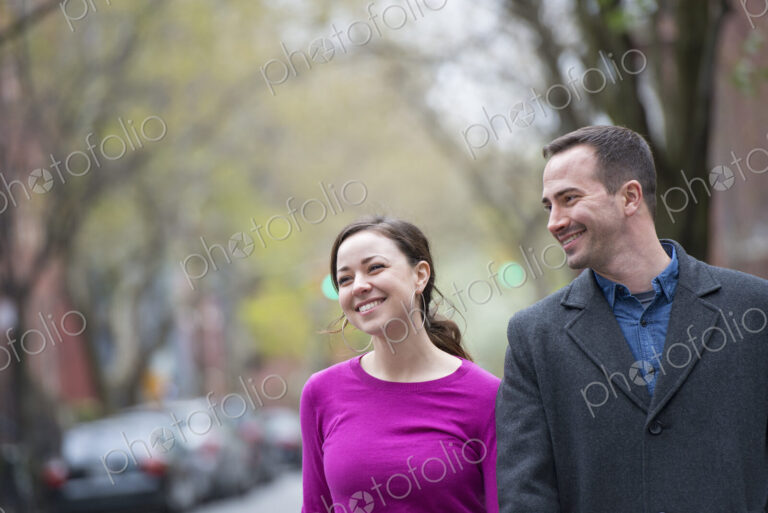 A couple, a man and woman side by side on a city street.