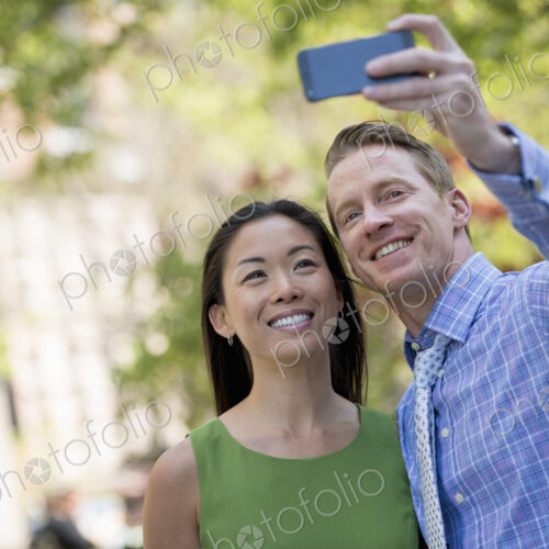 A couple, a man and woman taking a selfy with a smart phone. A couple, a man and woman taking a selfy with a smart phone.
