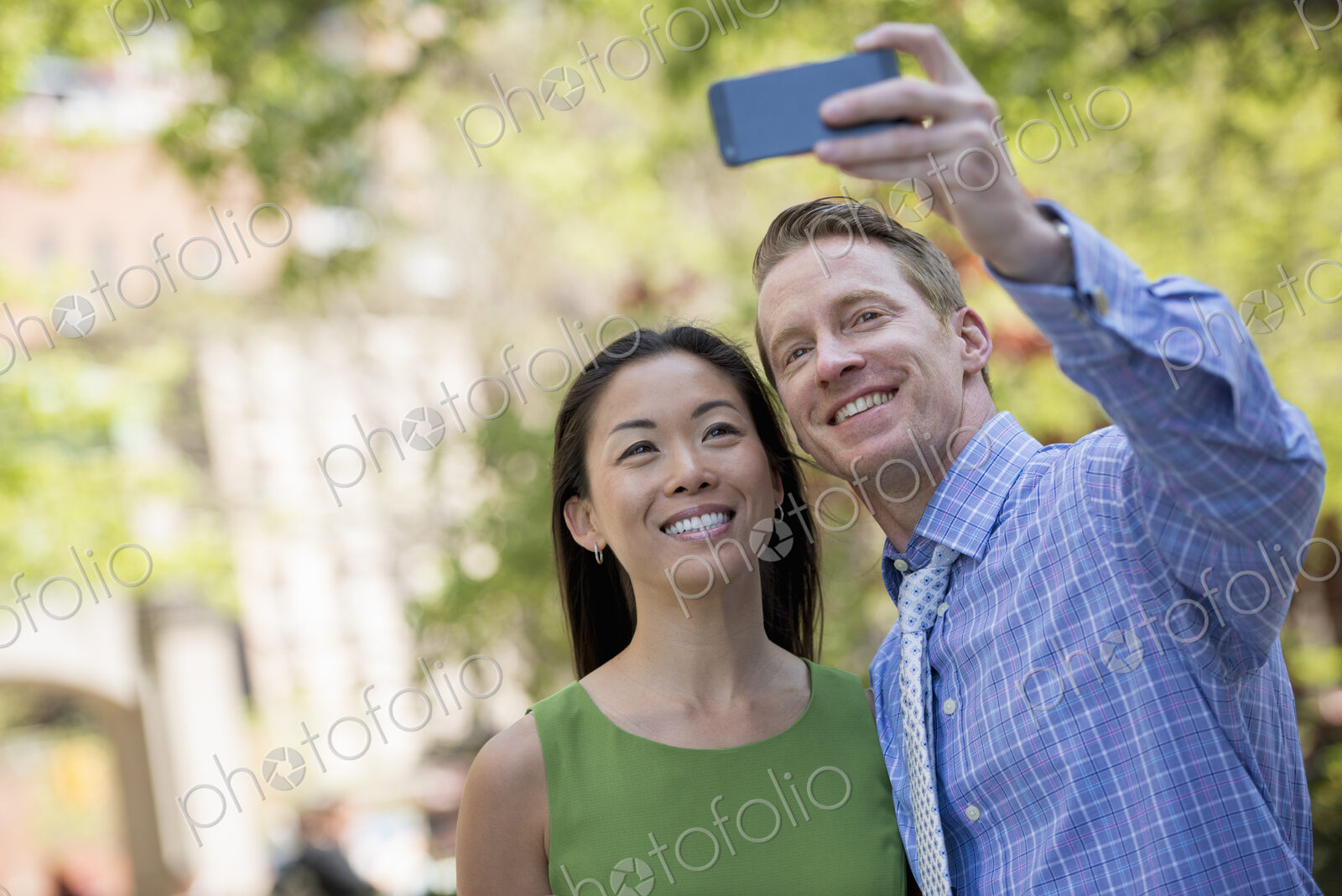 A couple, a man and woman taking a selfy with a smart phone.
