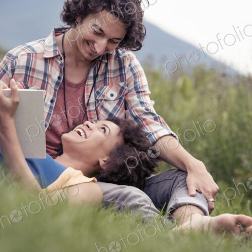 A couple, a woman with an open book looking up at a man smiling at him. A couple, a woman with an open book looking up at a man smiling at him.