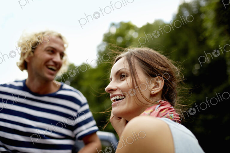 A couple, a young man and woman outdoors in woodland.