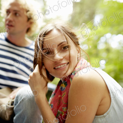 A couple, a young man and woman outdoors in woodland.