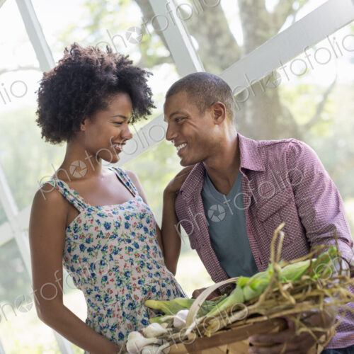 A couple at a table in a farmhouse, flirting and laughing.