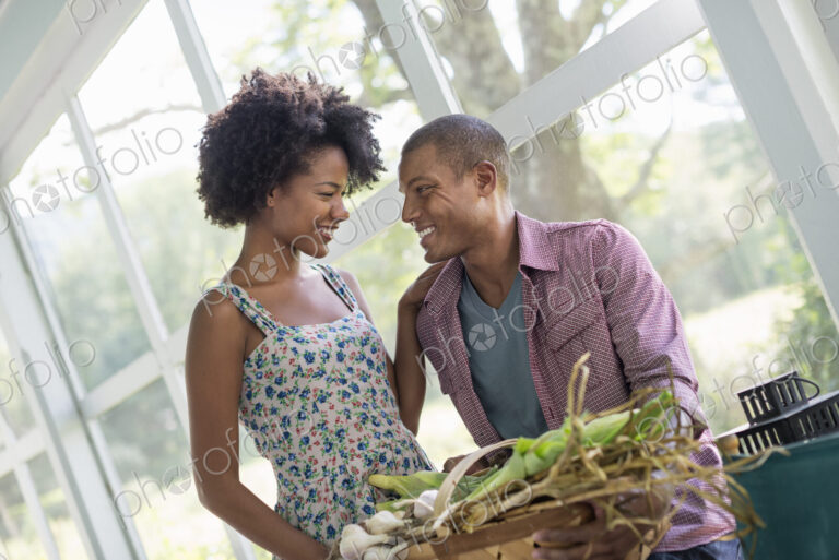 A couple at a table in a farmhouse, flirting and laughing.