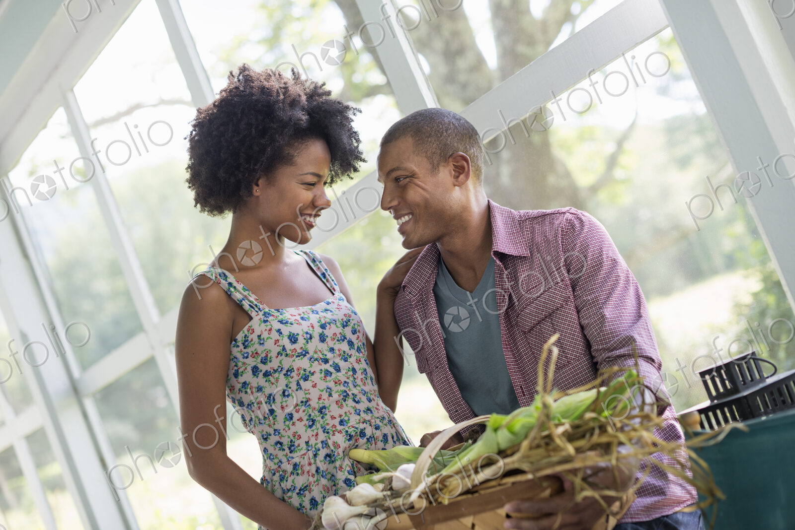 A couple at a table in a farmhouse, flirting and laughing.