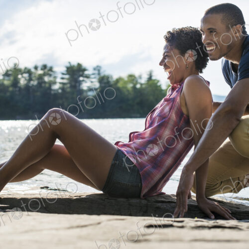 A couple close together by a lake in summer. A couple close together by a lake in summer.