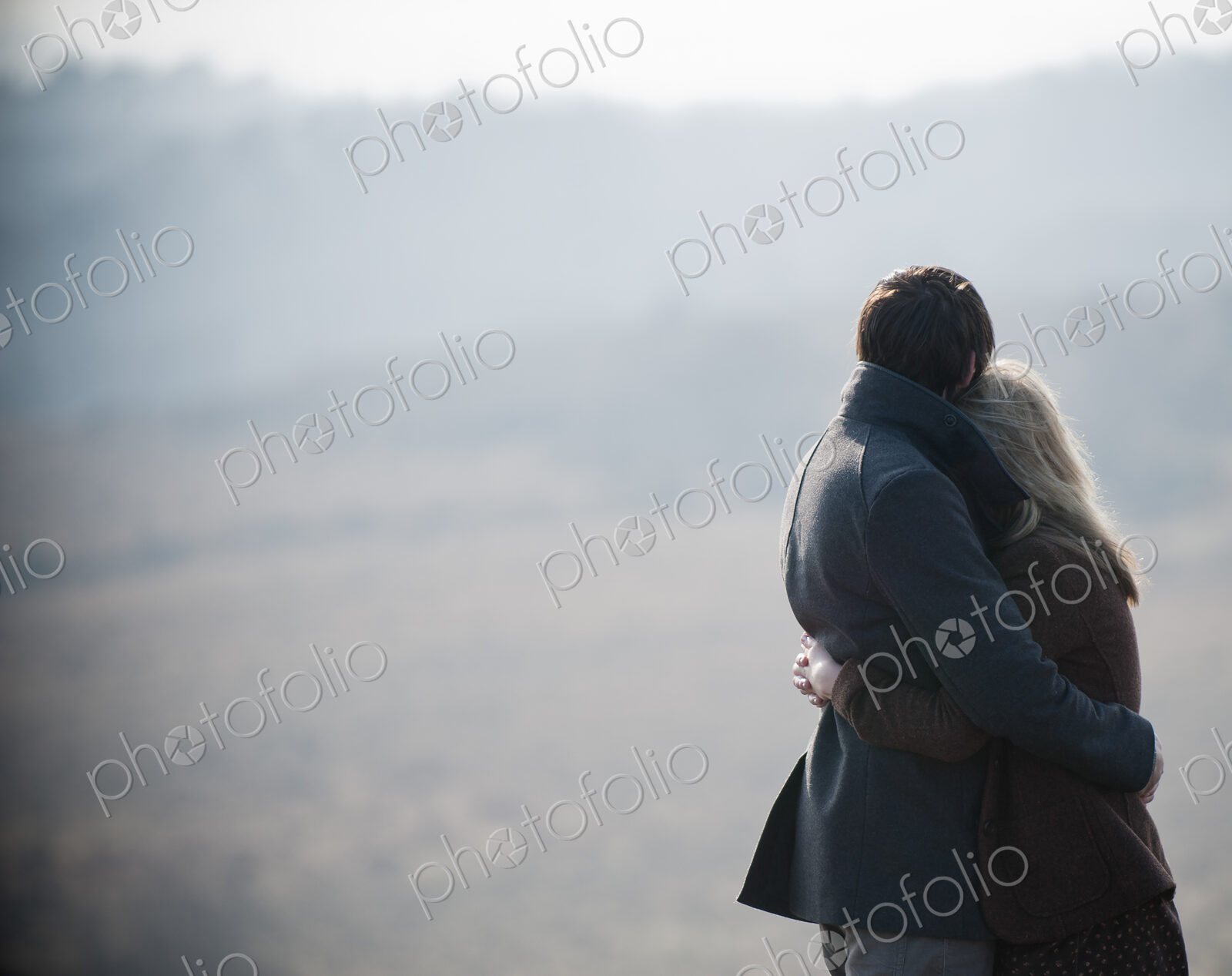 A couple embracing. Standing in a field in the country.