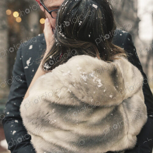 A couple, lovers kissing in lightly fall ing snow in the city. A couple, lovers kissing in lightly fall ing snow in the city.