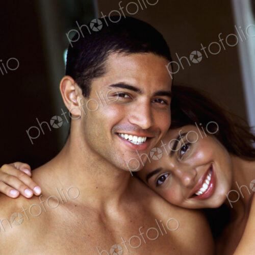 A couple, man and woman, embracing and laughing.