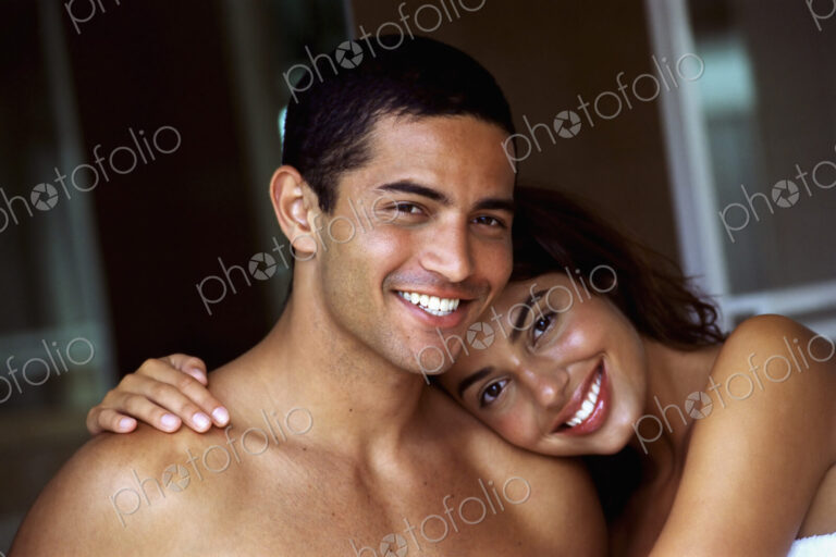 A couple, man and woman, embracing and laughing.
