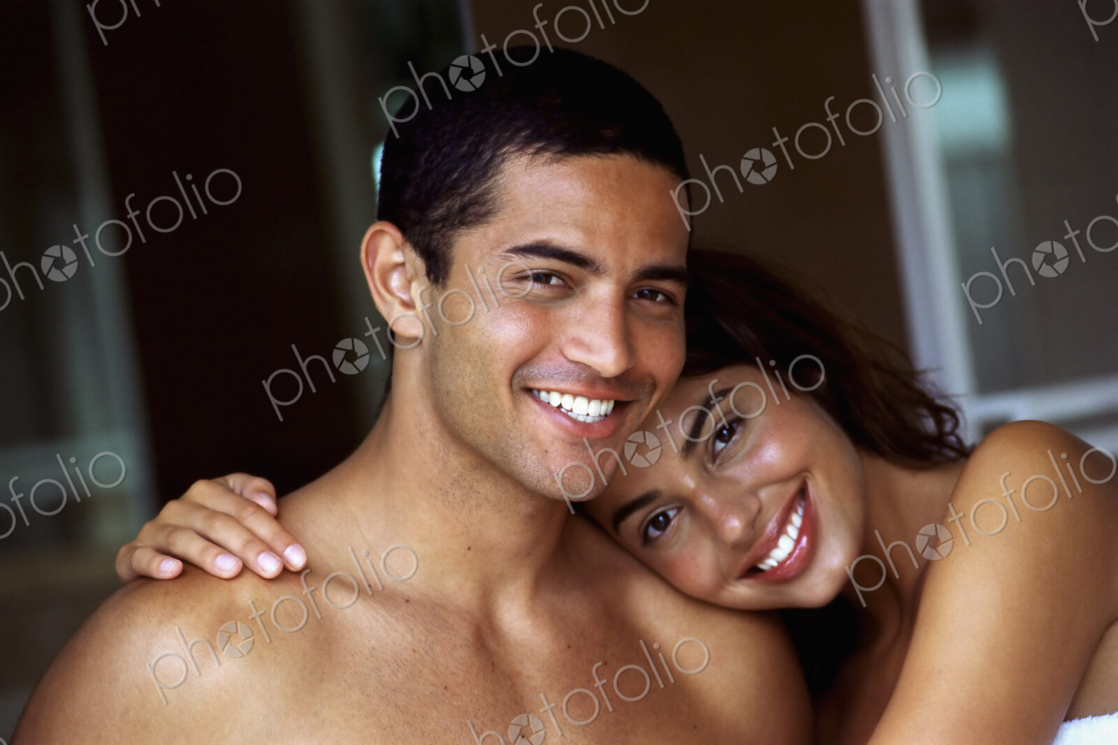 A couple, man and woman, embracing and laughing.