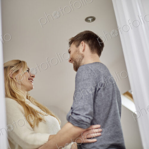 A couple, man and woman gazing at each other, low angle view through doorway. A couple, man and woman gazing at each other, low angle view through doorway.