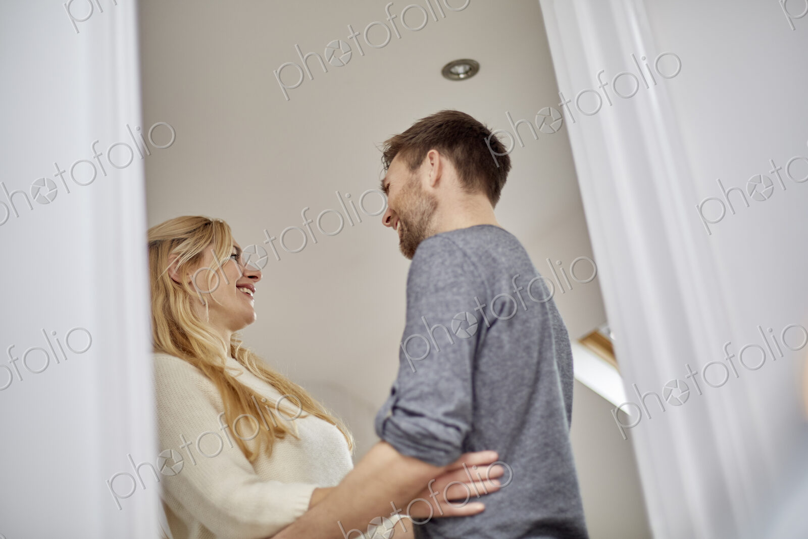 A couple, man and woman gazing at each other, low angle view through doorway.