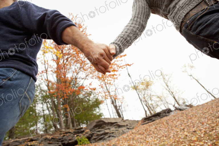 A couple, man and woman on a day out in autumn. Holding hands.