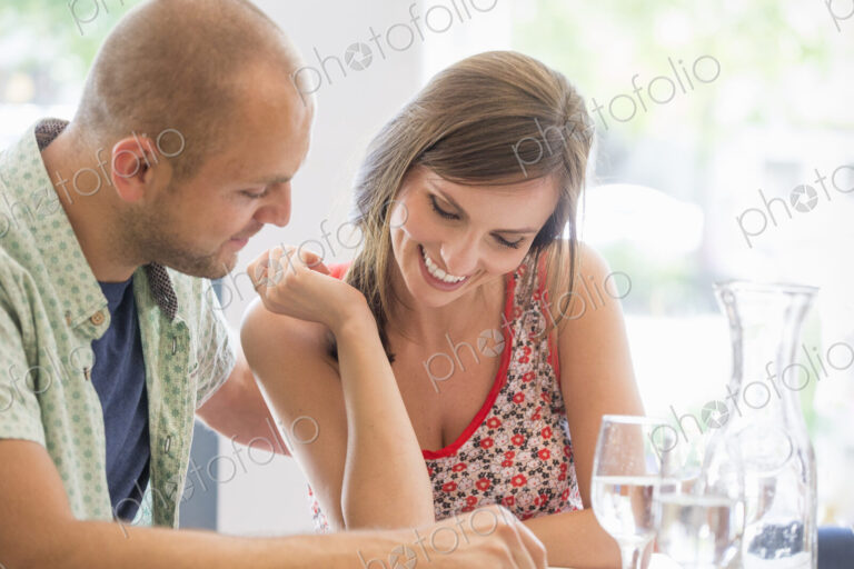 A couple, man and woman sitting in a restaurant looking at a menu.
