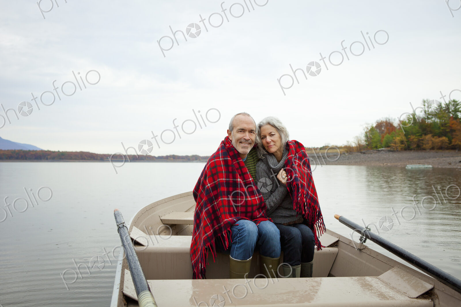 A couple, man and woman sitting in a rowing boat on the water on an autumn day.…