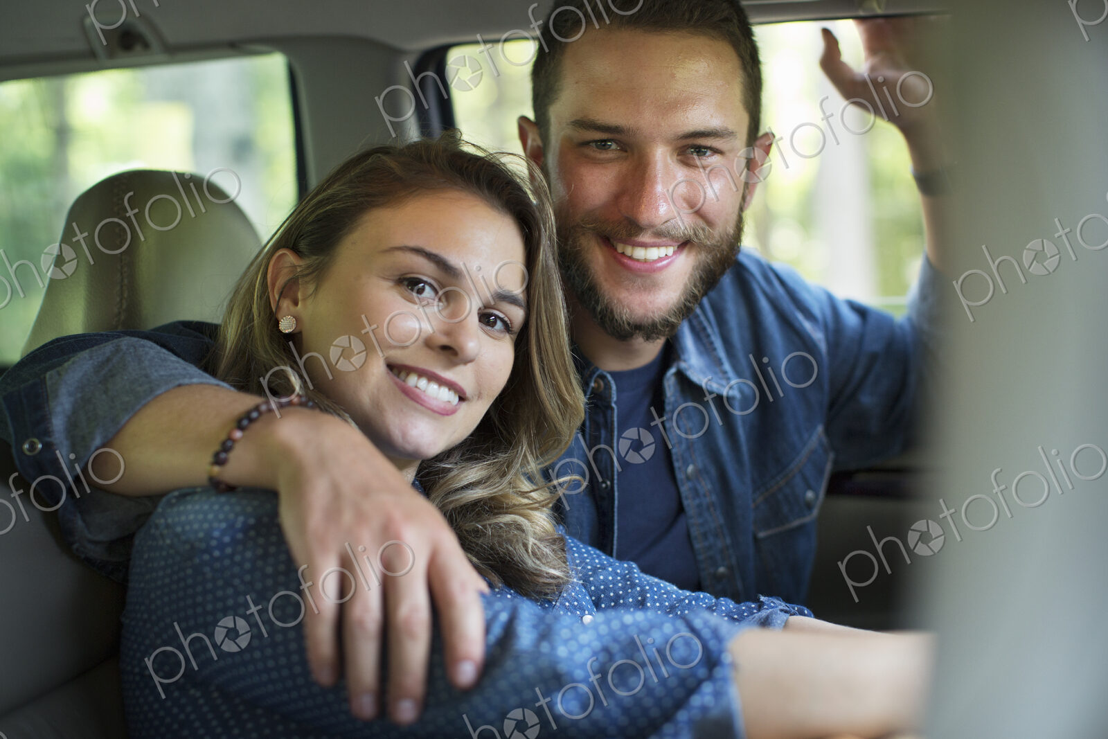 A couple, man and woman sitting inside a car.