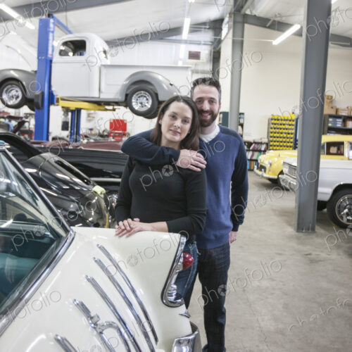 A couple, mechanics who work in a classic car auto repair shop. Man and woman. A couple, mechanics who work in a classic car auto repair shop. Man and woman.