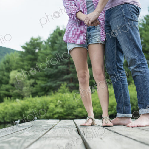 A couple on a wooden jetty by a lake.