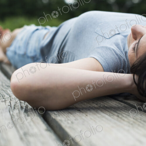 A couple relaxing on a jetty overlooking a mountain lake.