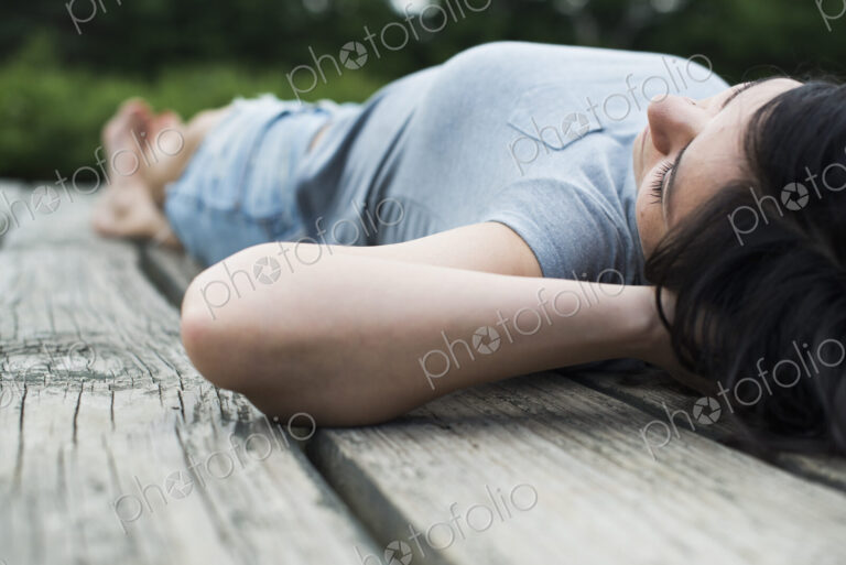 A couple relaxing on a jetty overlooking a mountain lake.