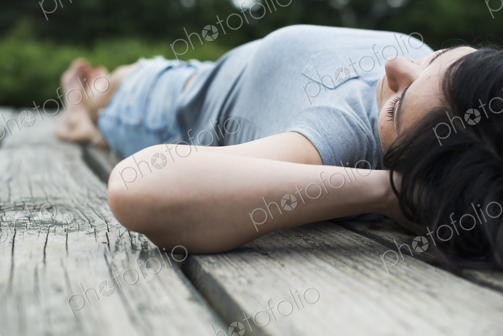 A couple relaxing on a jetty overlooking a mountain lake.