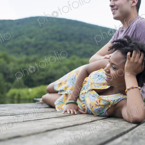 A couple relaxing on a jetty overlooking a mountain lake. A couple relaxing on a jetty overlooking a mountain lake.