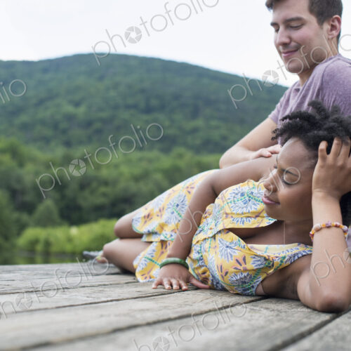 A couple relaxing on a jetty overlooking a mountain lake. A couple relaxing on a jetty overlooking a mountain lake.