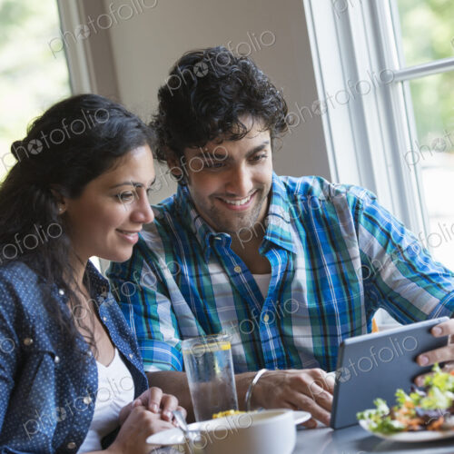 A couple seated looking at a digital tablet. A couple seated looking at a digital tablet.