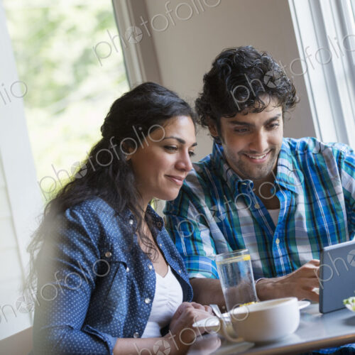 A couple seated looking at a digital tablet. A couple seated looking at a digital tablet.