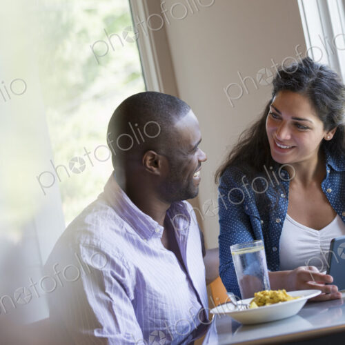 A couple seated looking at a digital tablet. A couple seated looking at a digital tablet.