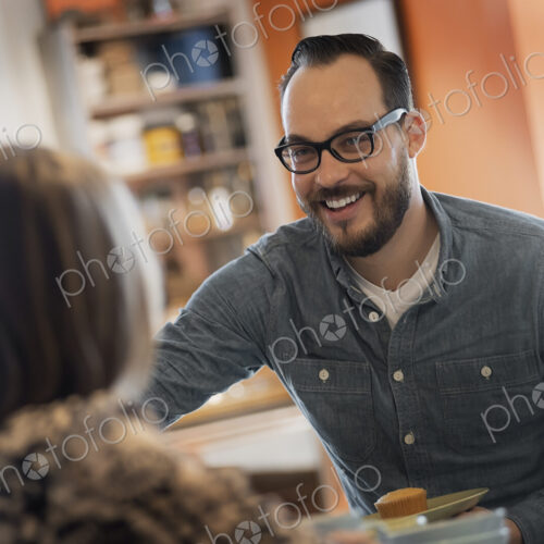 A couple sitting in a coffeeshop smiling and talking over a cup of coffee. A couple sitting in a coffeeshop smiling and talking over a cup of coffee.