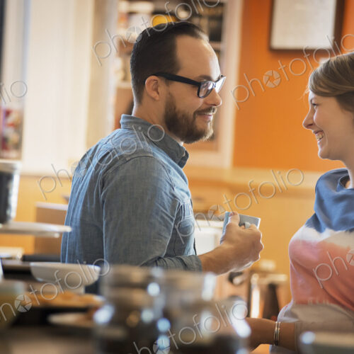 A couple sitting in a coffeeshop smiling and talking over a cup of coffee. A couple sitting in a coffeeshop smiling and talking over a cup of coffee.