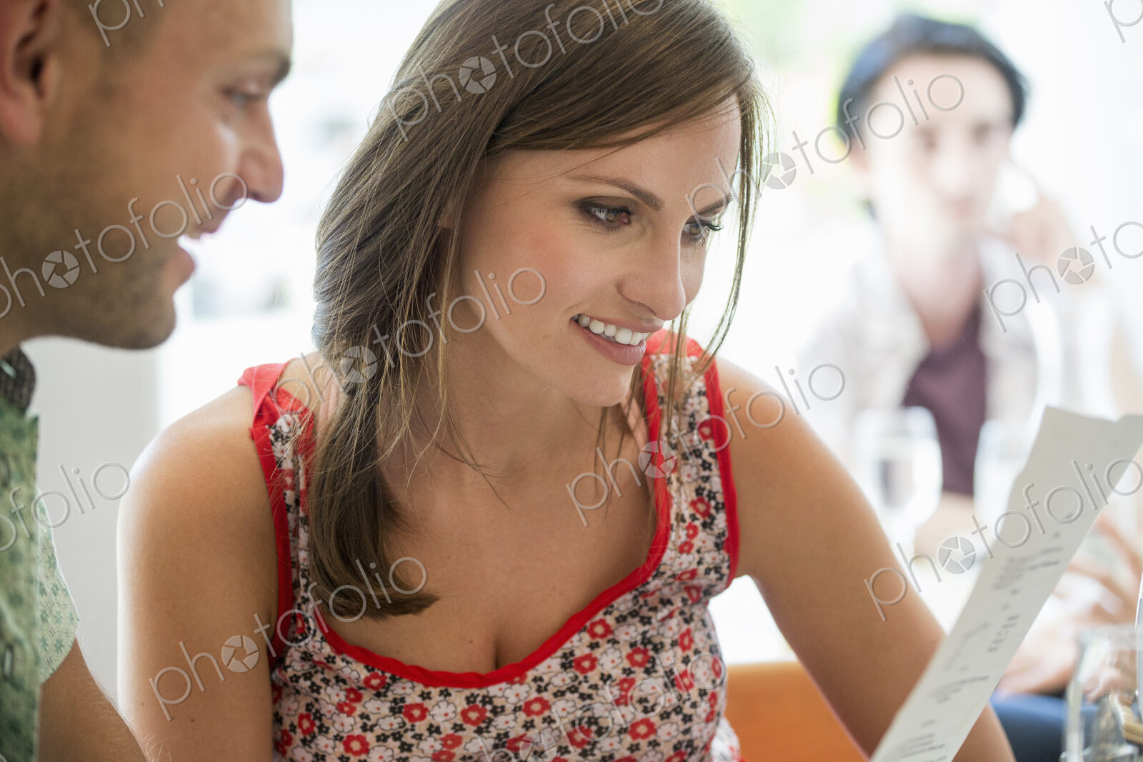 A couple sitting in a restaurant looking at a menu.