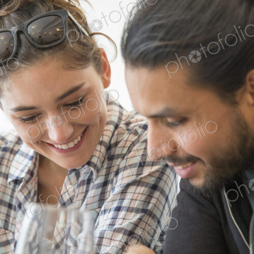 A couple sitting in a restaurant looking at a menu.