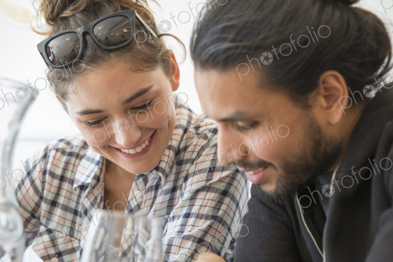 A couple sitting in a restaurant looking at a menu.