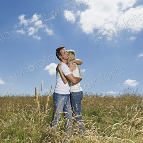 A couple standing in a field of wheat hugging. A couple standing in a field of wheat hugging.