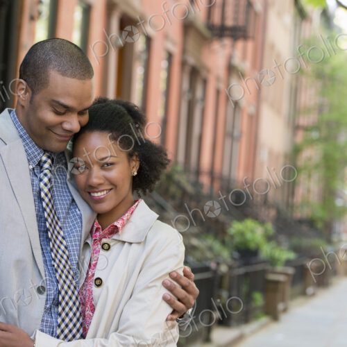 A couple standing side by side on a city street. A couple standing side by side on a city street.