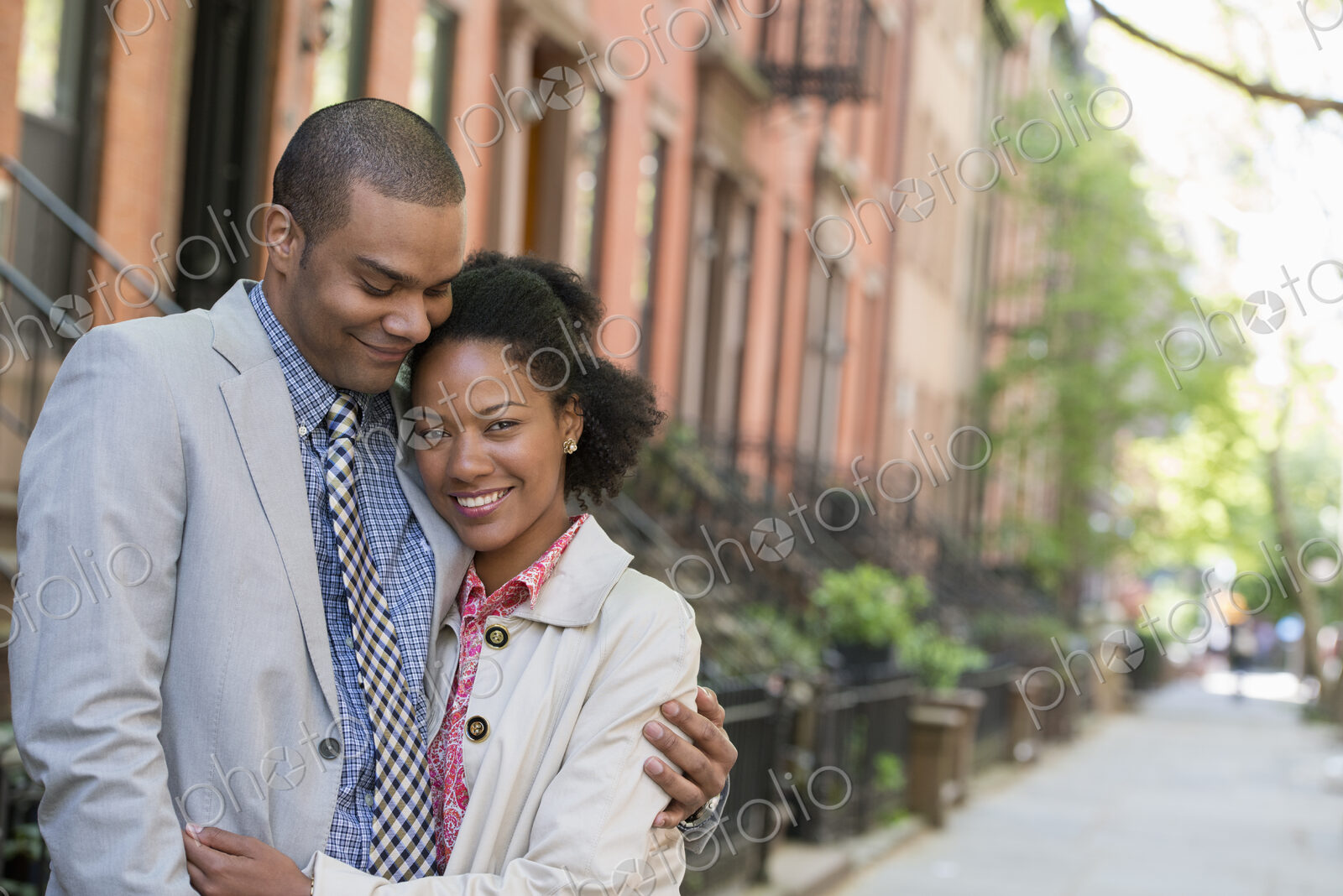 A couple standing side by side on a city street.