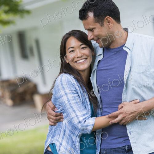 A couple standing with arms around each other.
