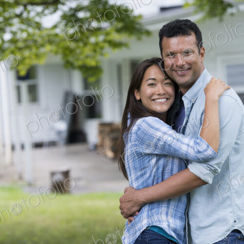 A couple standing with arms around each other.