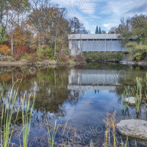 A covered bridge across a river in autumn. A covered bridge across a river in autumn.