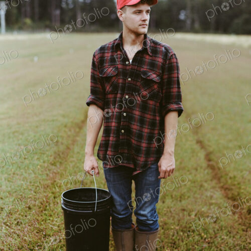 A cranberry farm in Massachusetts. Crops in the fields. A young man working on the… A cranberry farm in Massachusetts. Crops in the fields. A young man working on the…