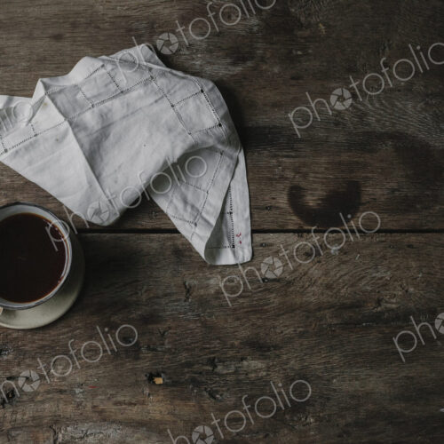 A cup of coffee and a napkin on a table. A cup of coffee and a napkin on a table.